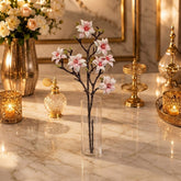 Home Sajawat artificial magnolia branch with pink and white flowers in a clear glass vase on a marble table.