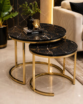 Home Sajawat round nesting coffee tables with black faux marble tops and gold metal frames in a modern living room.