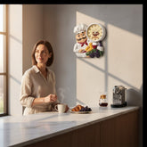 Home Sajawat chef-themed wall clock with coffee motif hanging in a bright, modern kitchen above a woman drinking tea.
