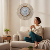 Home Sajawat gold metal wall clock with intricate branch design and white face with Arabic numerals.