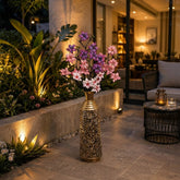 Home Sajawat decorative floor vase with pink and purple artificial magnolia flowers in a gold filigree metal stand.