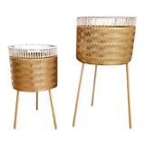 Set of two Home Sajawat gold metal planters with white woven rims and gold stands. Textured finish.