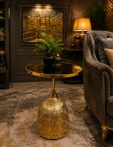 Home Sajawat gold metal side table with a reflective circular top and an intricate laser-cut bell-shaped base.