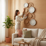 Home Sajawat set of four decorative wall plates with woven rattan frames and embossed botanical motifs. Neutral tone plates with leaf patterns.