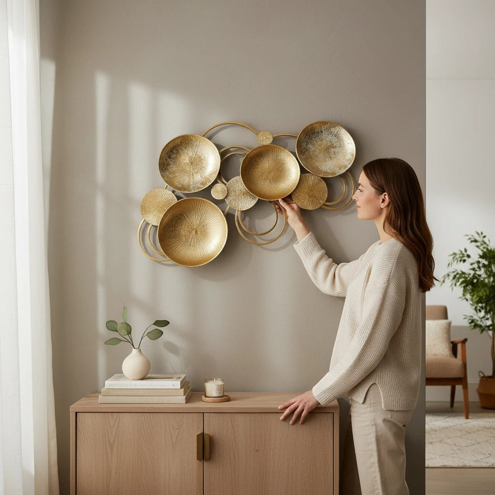 Home Sajawat abstract metal wall art sculpture with gold circular discs and silver accents. Textured surfaces and loops create movement.