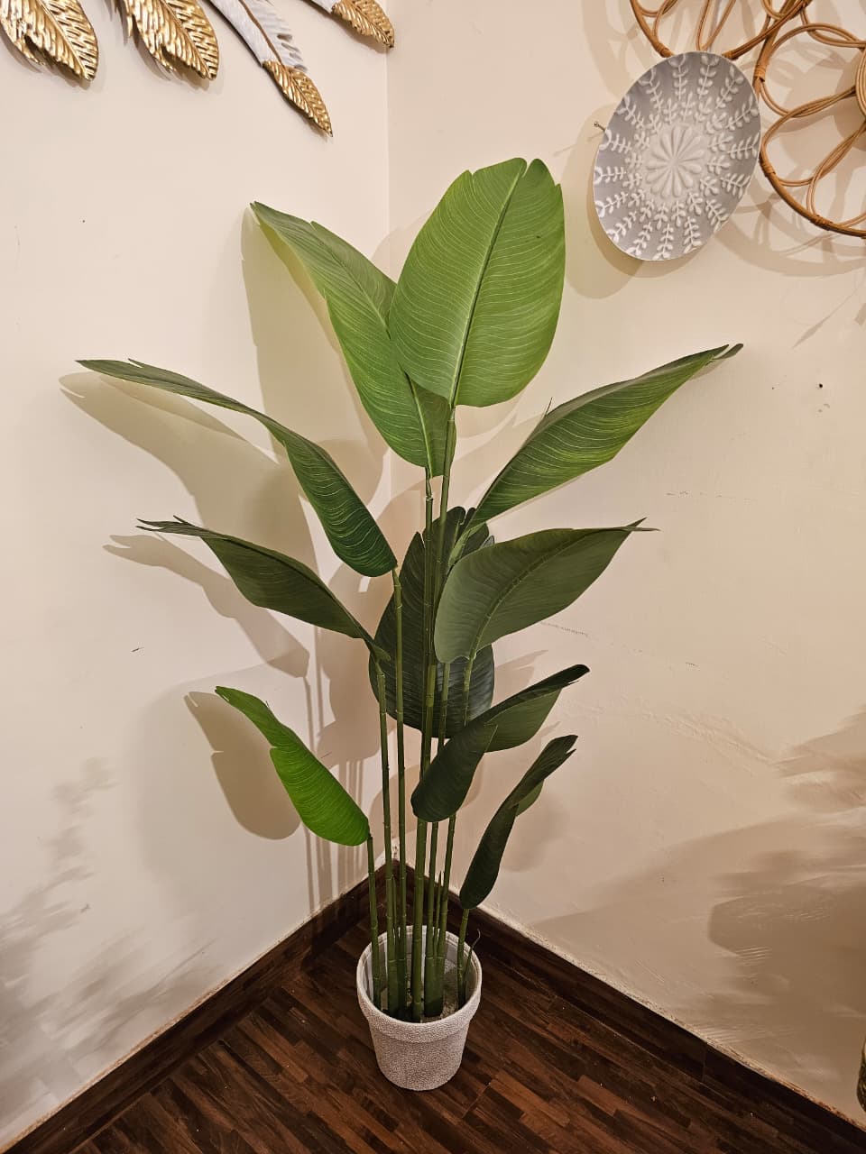 Home Sajawat artificial Bird of Paradise floor plant with large green leaves in a textured grey pot for home decor.