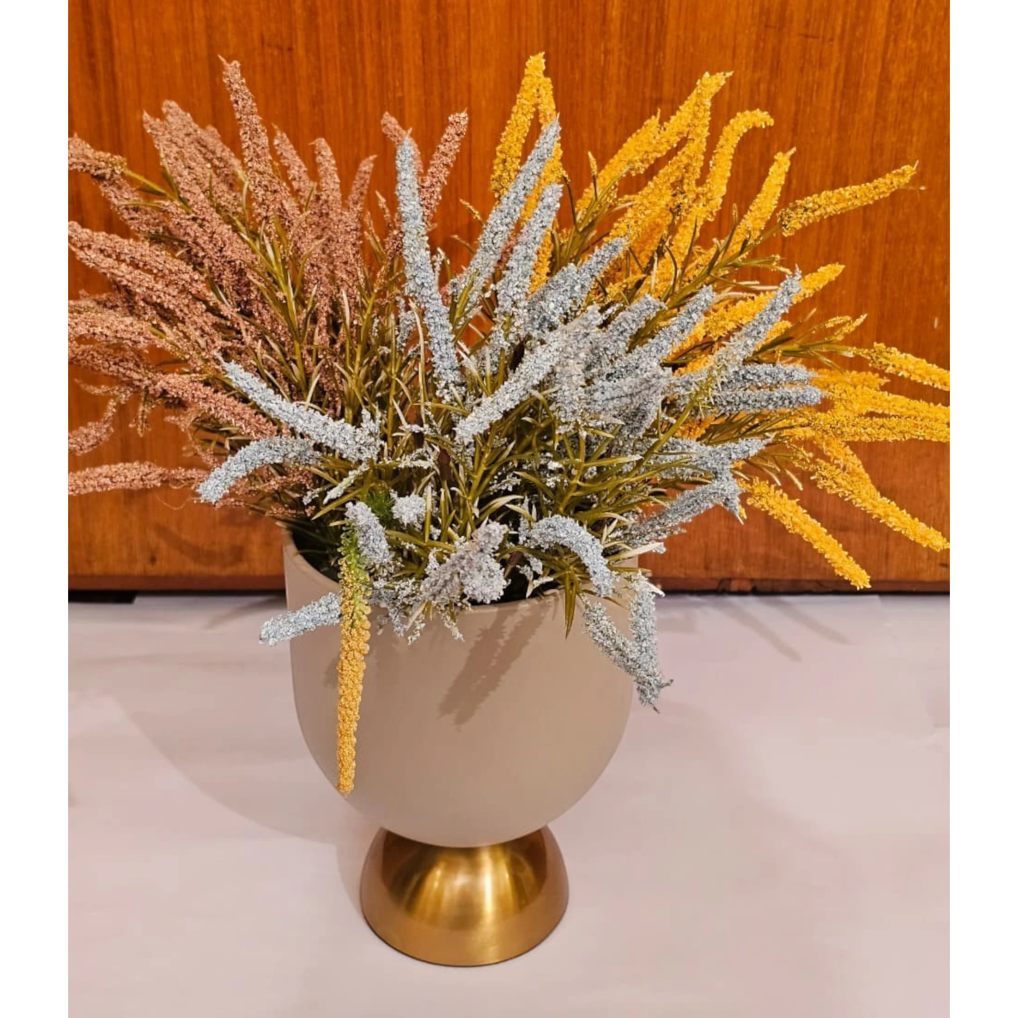 Home Sajawat artificial floral arrangement with yellow, blue, and pink textured grasses in a matte beige gold vase.