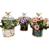 Home Sajawat set of three artificial flower pots with marble-effect ceramic, gold metal frames, and bird accents.