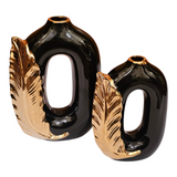 Home Sajawat set of two modern black ceramic vases with metallic gold feather accents and open-center silhouettes.