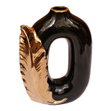 Home Sajawat black ceramic vase with a metallic gold leaf accent and a modern hollow oval silhouette.