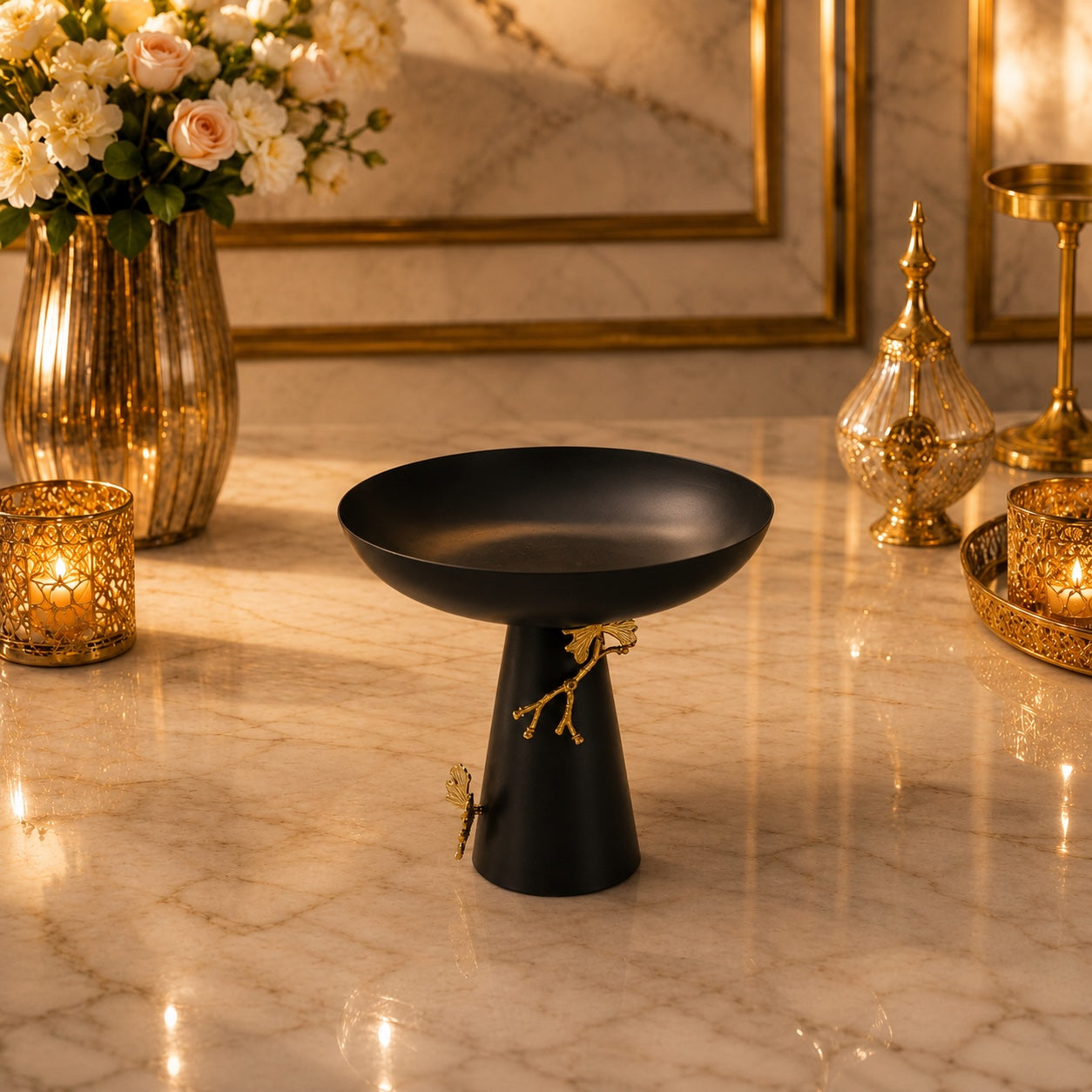 Home Sajawat matte black pedestal bowl with gold ginkgo leaf accents on a marble table