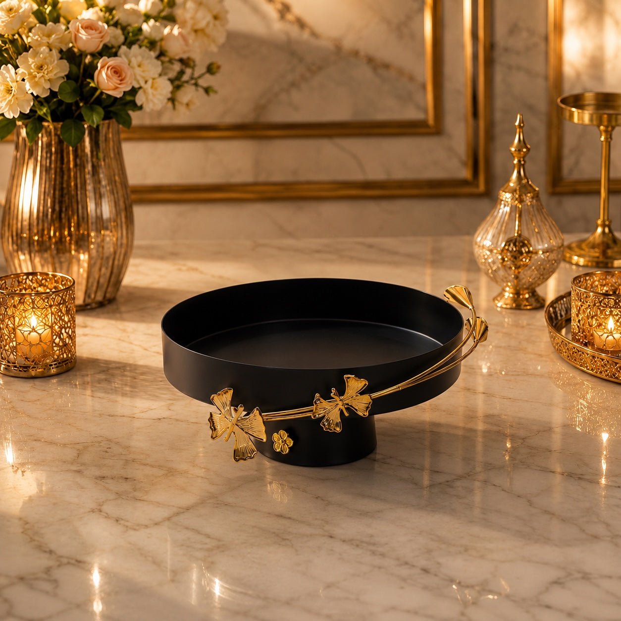 Home Sajawat matte black pedestal serving tray with elegant gold floral rim detailing on a marble tabletop