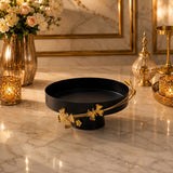 Home Sajawat matte black pedestal serving tray with elegant gold floral rim detailing on a marble tabletop