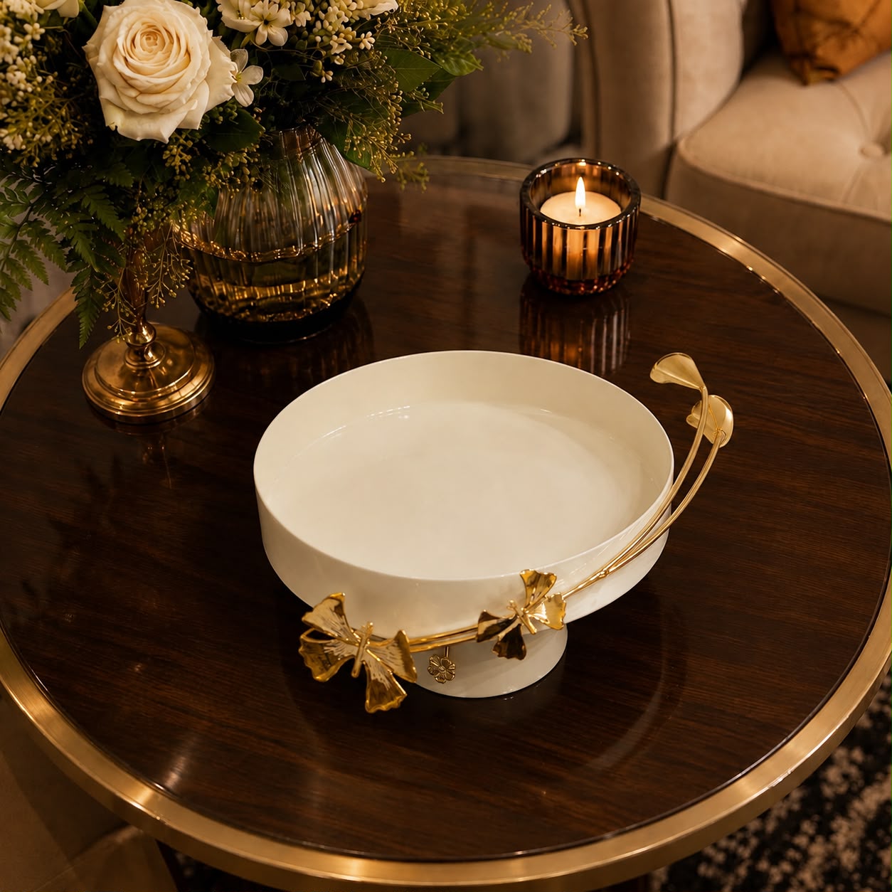 Home Sajawat cream pedestal bowl with gold butterfly and floral metal accents displayed on a dark wood table.