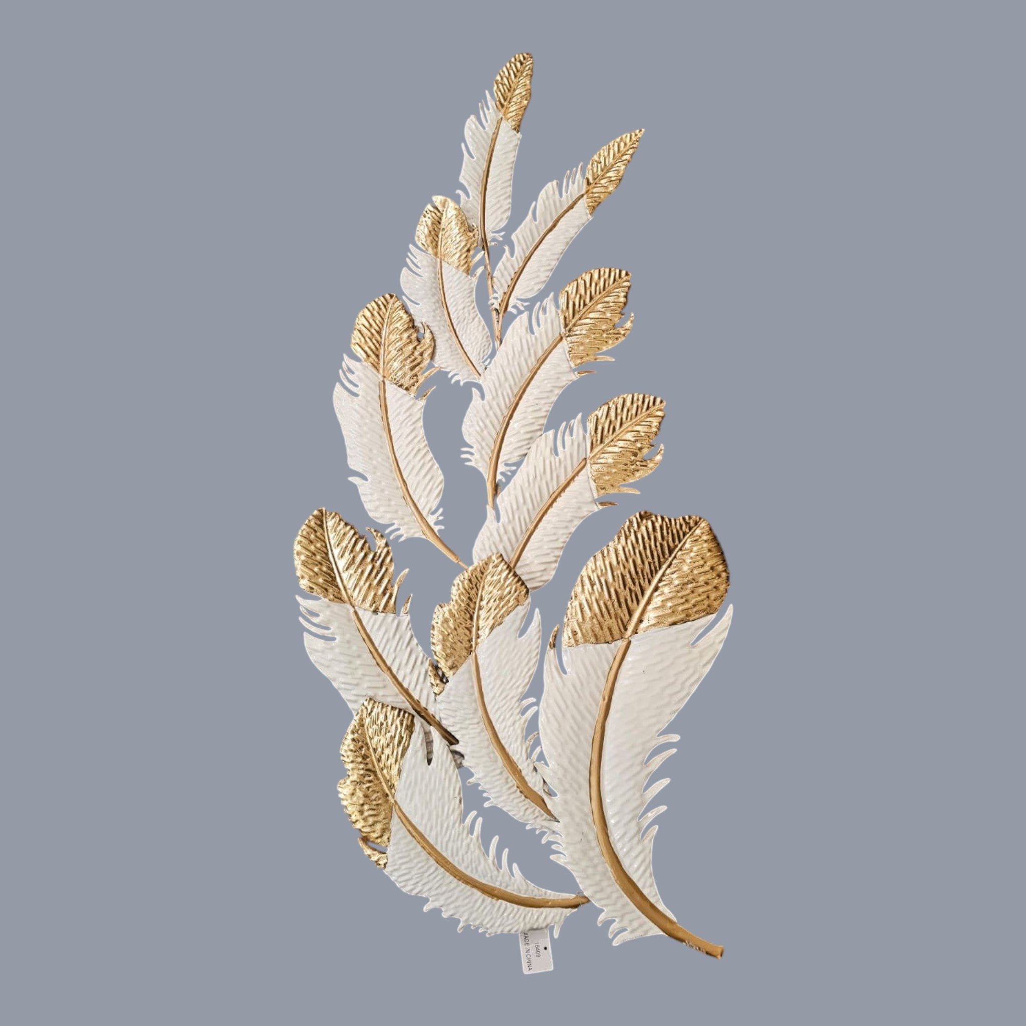 Home Sajawat white metal feather wall art with gold tips and textured detailing. Elegant sculpture.
