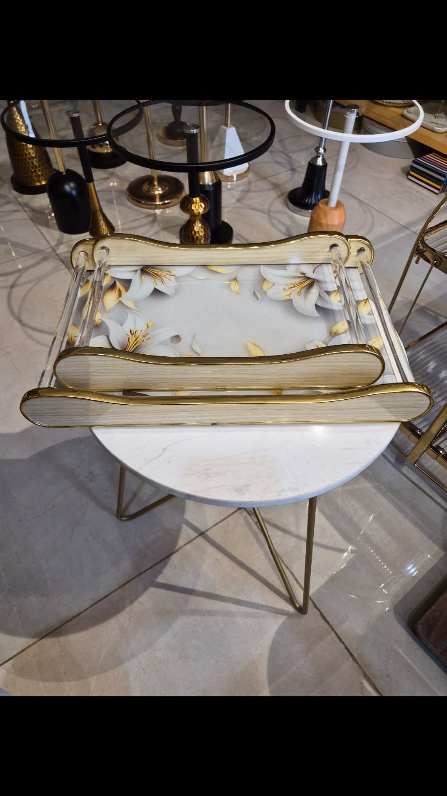 Home Sajawat decorative acrylic tray with white and gold floral design and wood-look handles with gold trim.