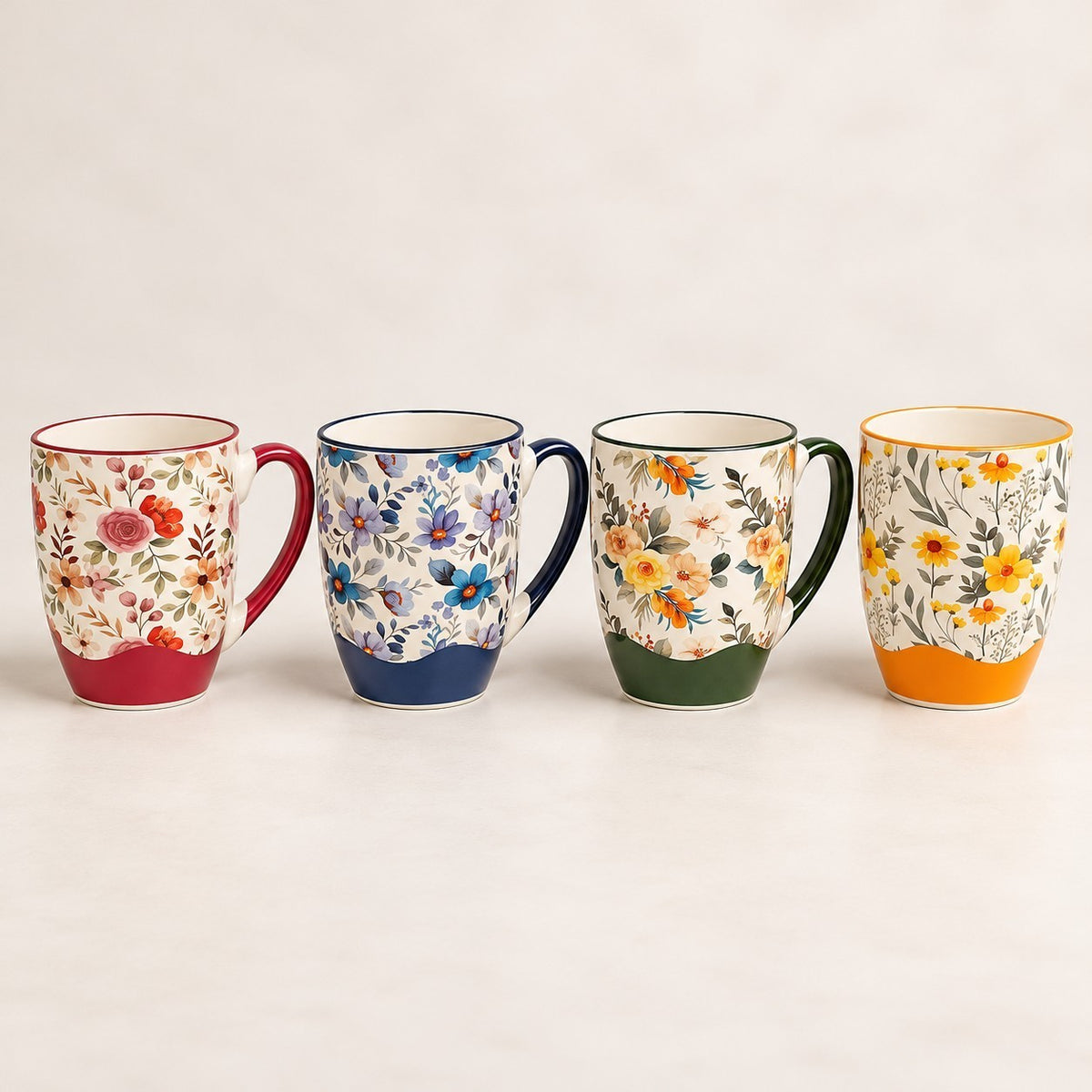 Home Sajawat set of four ceramic coffee mugs with vibrant solid bases and intricate interior floral patterns.