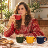 Home Sajawat ceramic coffee mug set with floral interior patterns, displayed on a table with a woman drinking tea.