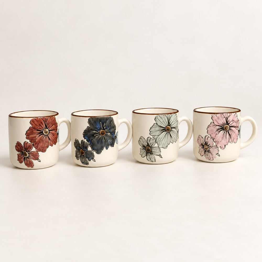 Home Sajawat ceramic coffee mug set featuring four mugs with unique hand-painted floral designs on a cream background.