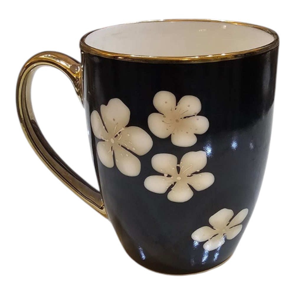 Home Sajawat black ceramic coffee mug with white floral pattern and elegant gold-toned handle and rim.