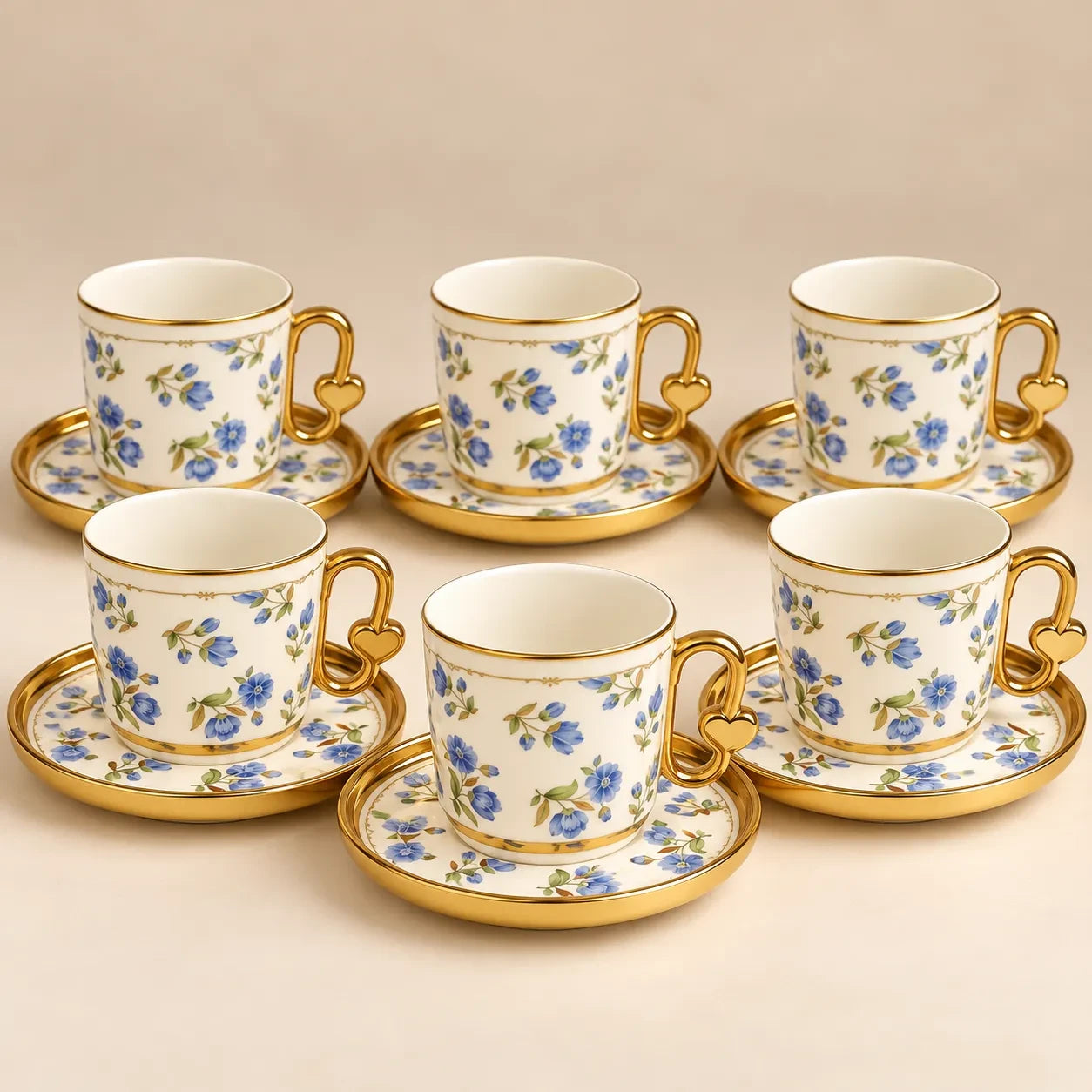 Home Sajawat porcelain tea cup and saucer set with blue floral patterns, gold rims, and heart-shaped handle details.