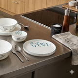 Home Sajawat white porcelain serving platter with delicate floral design and black trim.
