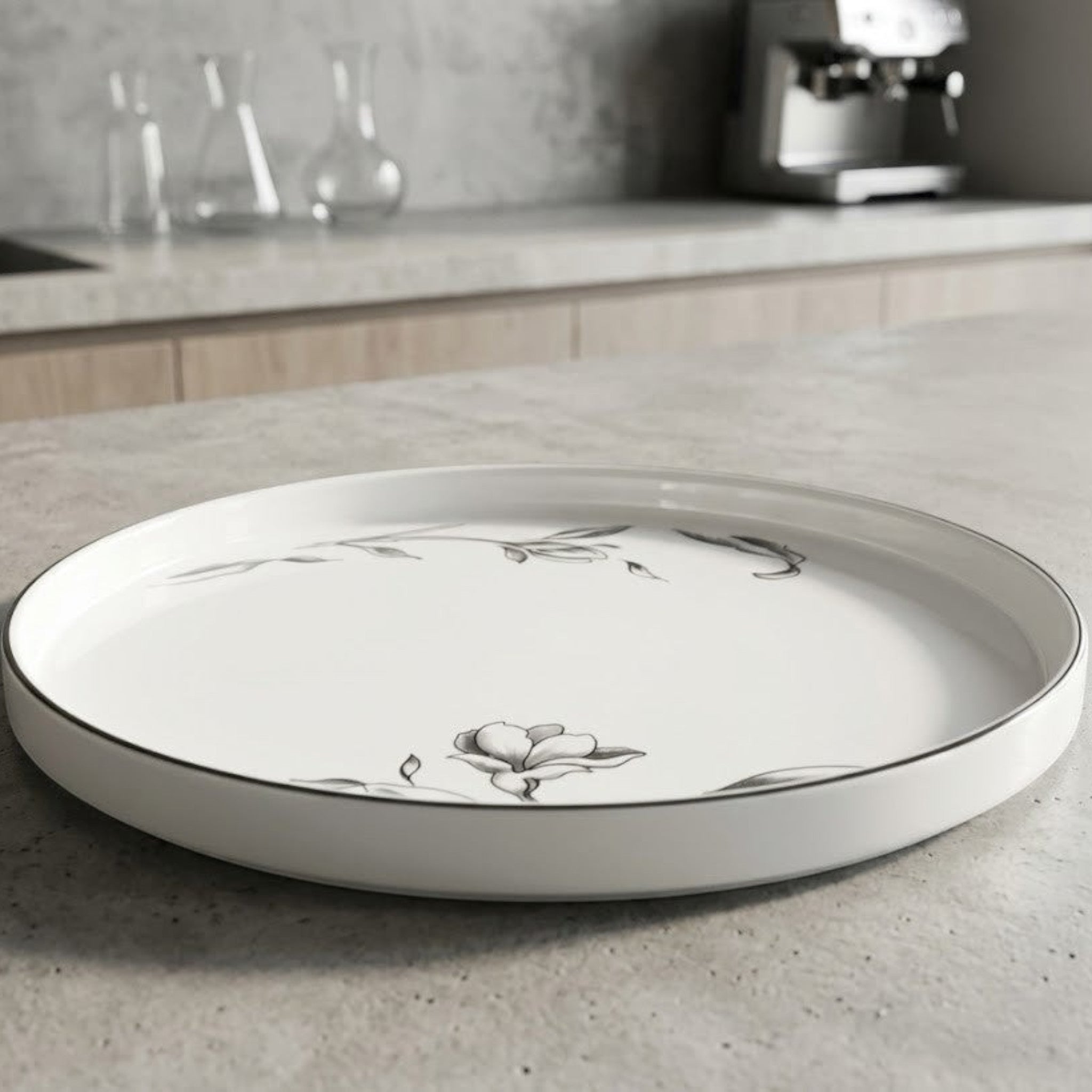 Home Sajawat white porcelain serving platter with floral design and black trim.