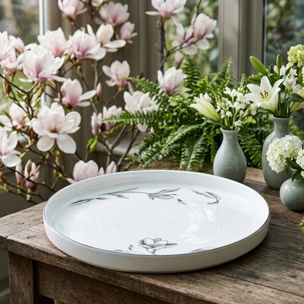 Home Sajawat white porcelain serving platter with delicate floral design and black trim.