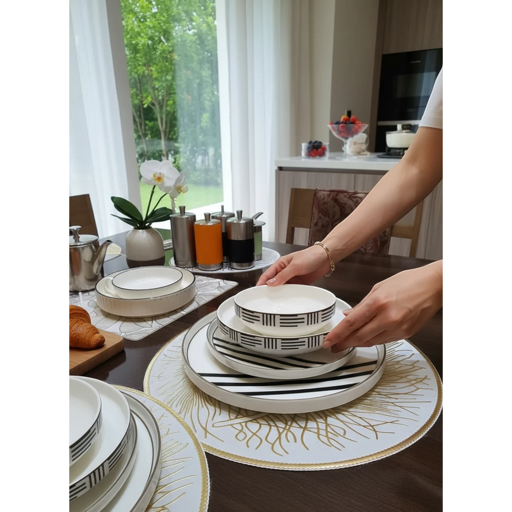 Home Sajawat white ceramic dinnerware set with black geometric pattern and gold rim. Includes plates and bowls.