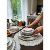 Home Sajawat white ceramic dinnerware set with black geometric pattern and gold rim. Includes plates and bowls.