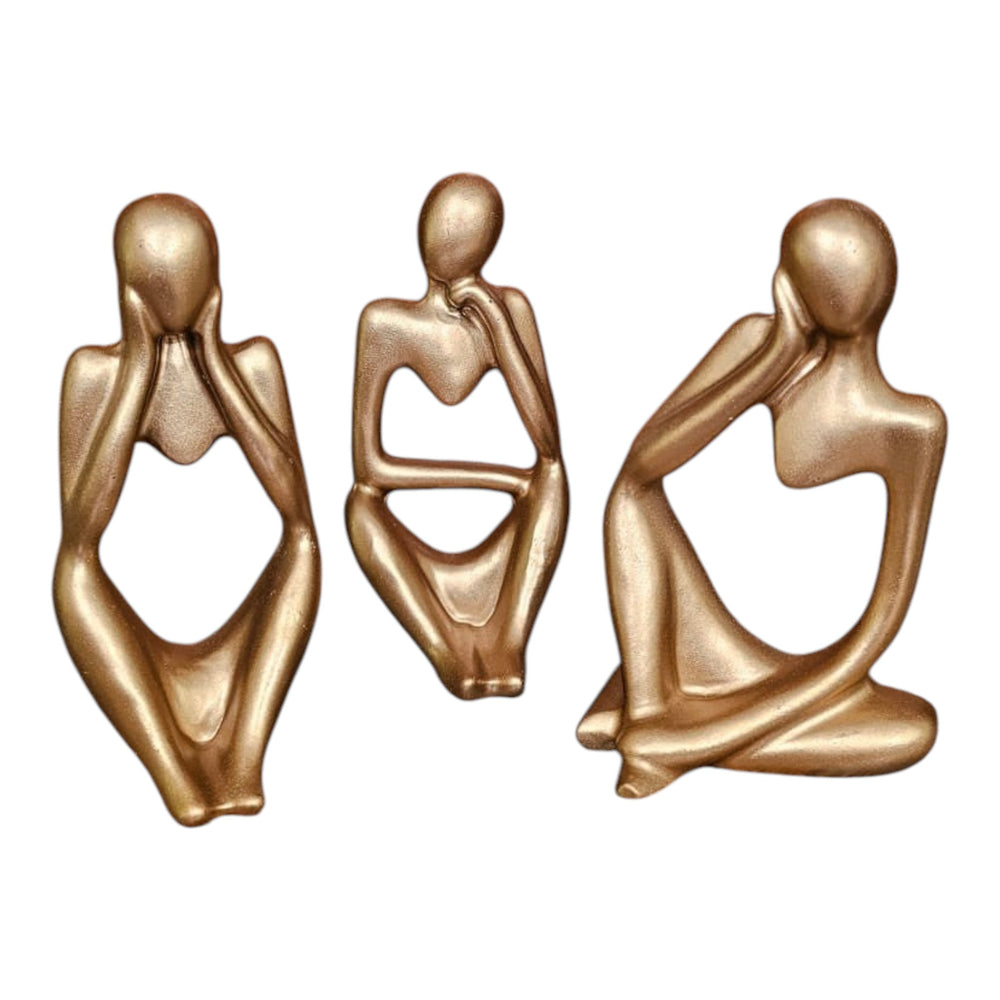 Home Sajawat set of three gold abstract thinker statues in different contemplative poses on a tiled table.