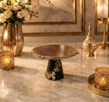 Home Sajawat decorative cake stand with a gold textured plate, matte black base, and elegant ginkgo leaf accents.