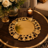 Home Sajawat gold decorative charger plate with intricate shell and scroll motifs on a dark wood table