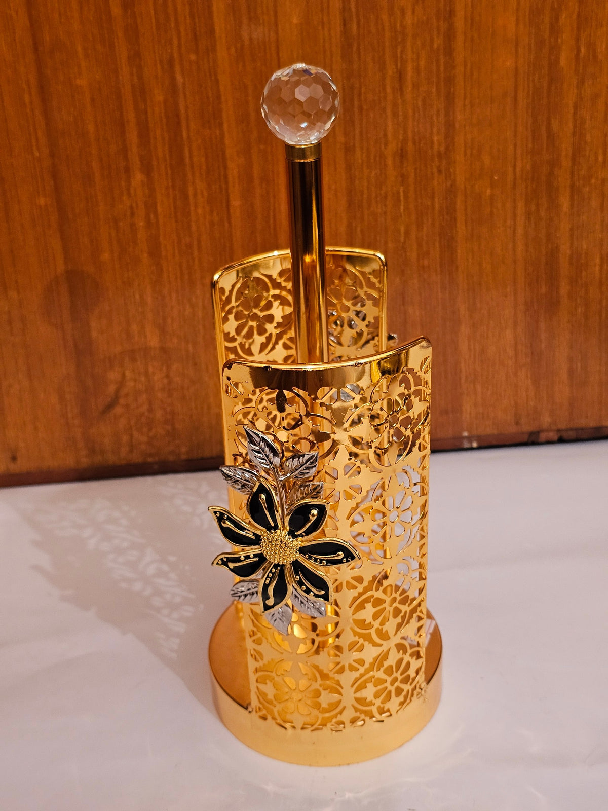 Home Sajawat gold metal paper towel holder with intricate laser-cut floral patterns and a crystal finial top