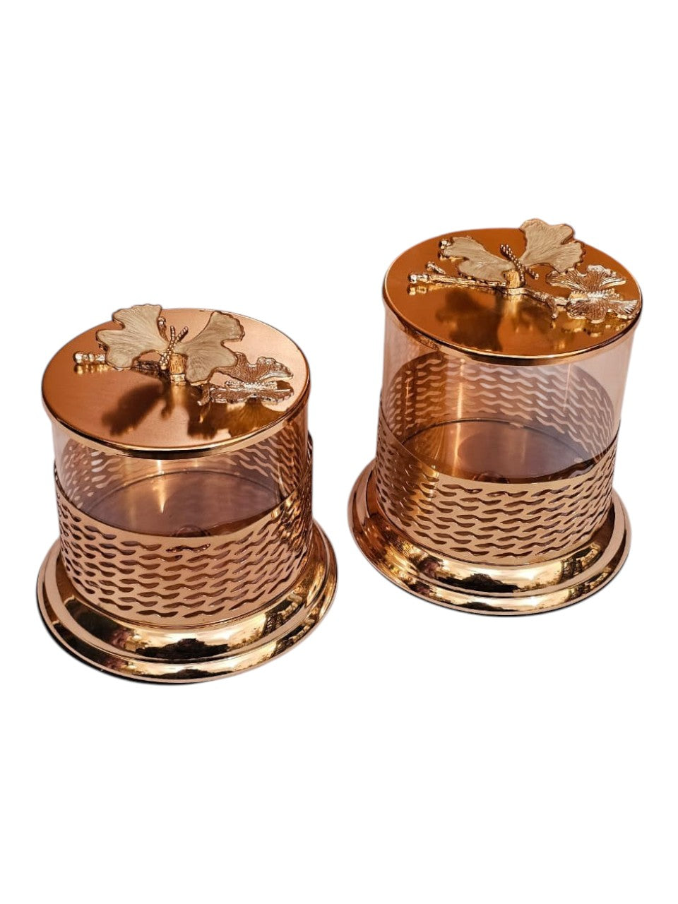Home Sajawat glass storage jars with gold lattice metalwork and floral lids on a white surface