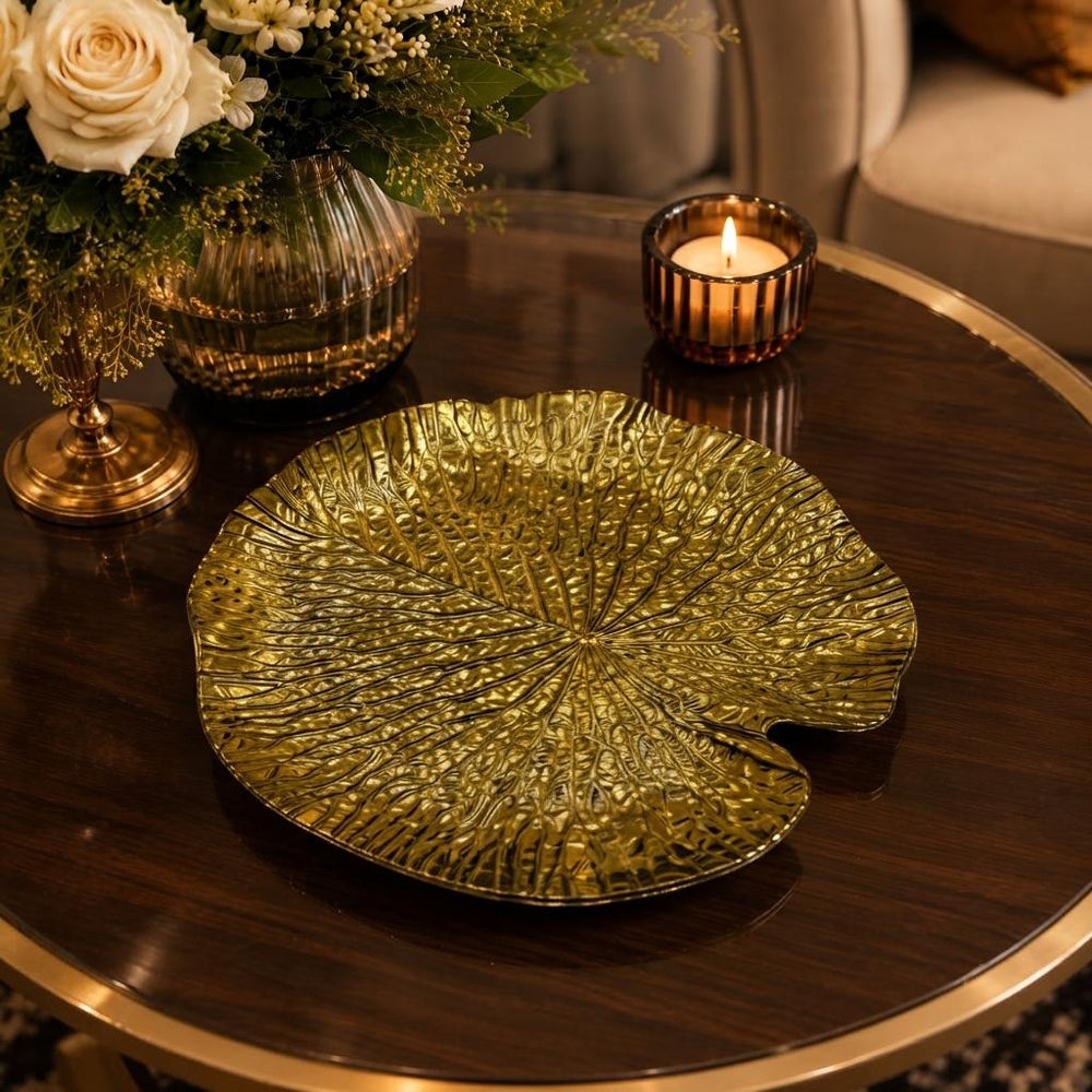 Home Sajawat gold leaf-shaped decorative charger plate with textured finish on a dark wooden table