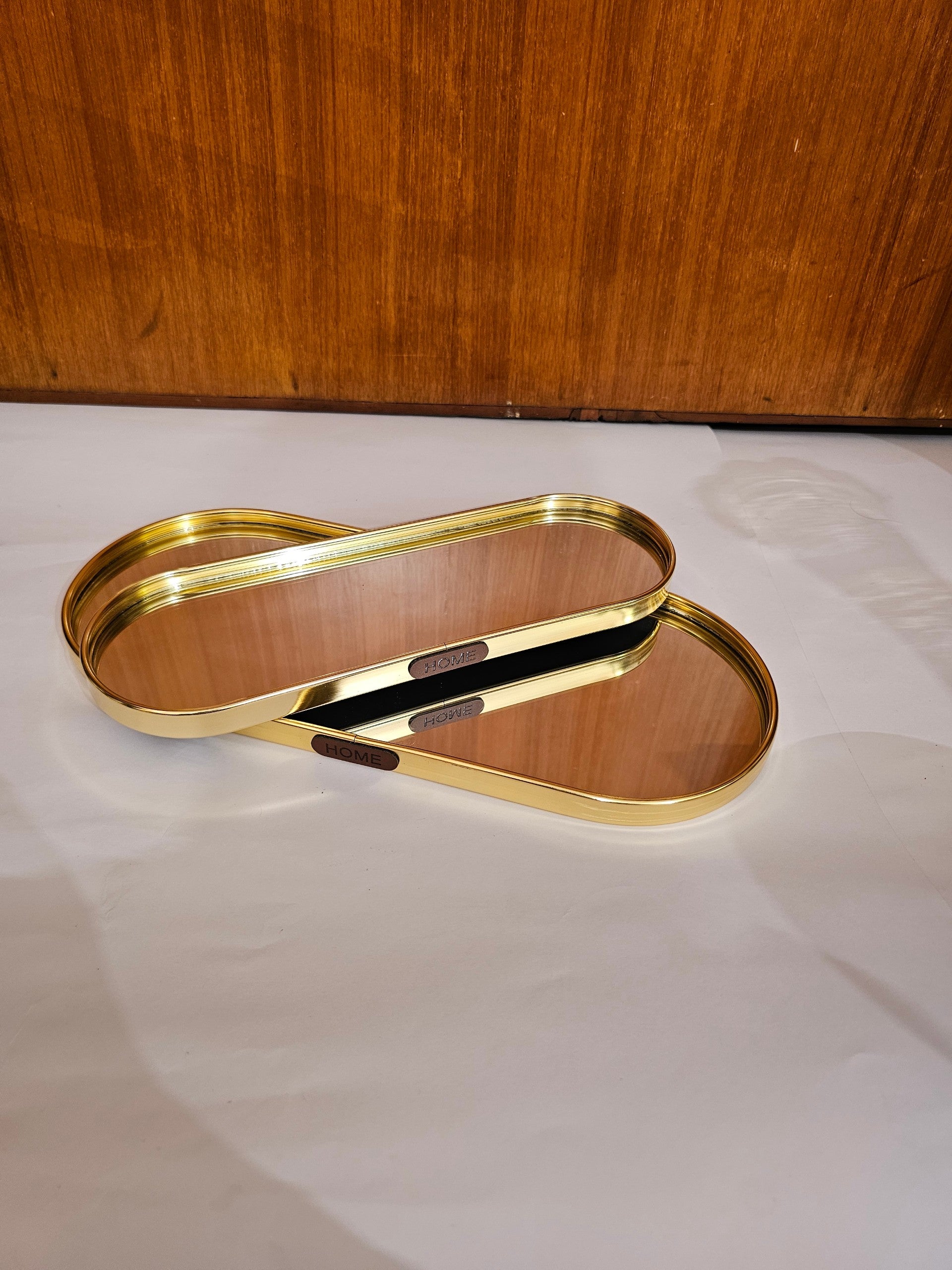 Home Sajawat oval mirrored vanity tray with a polished gold-tone metal frame and HOME label detail.