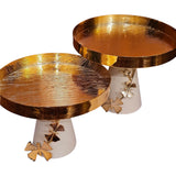 Home Sajawat set of two gold textured pedestal serving trays with white bases and decorative butterfly accents.
