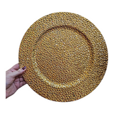 Home Sajawat gold decorative charger plate with a textured, faceted surface held by a hand for a formal table setting.