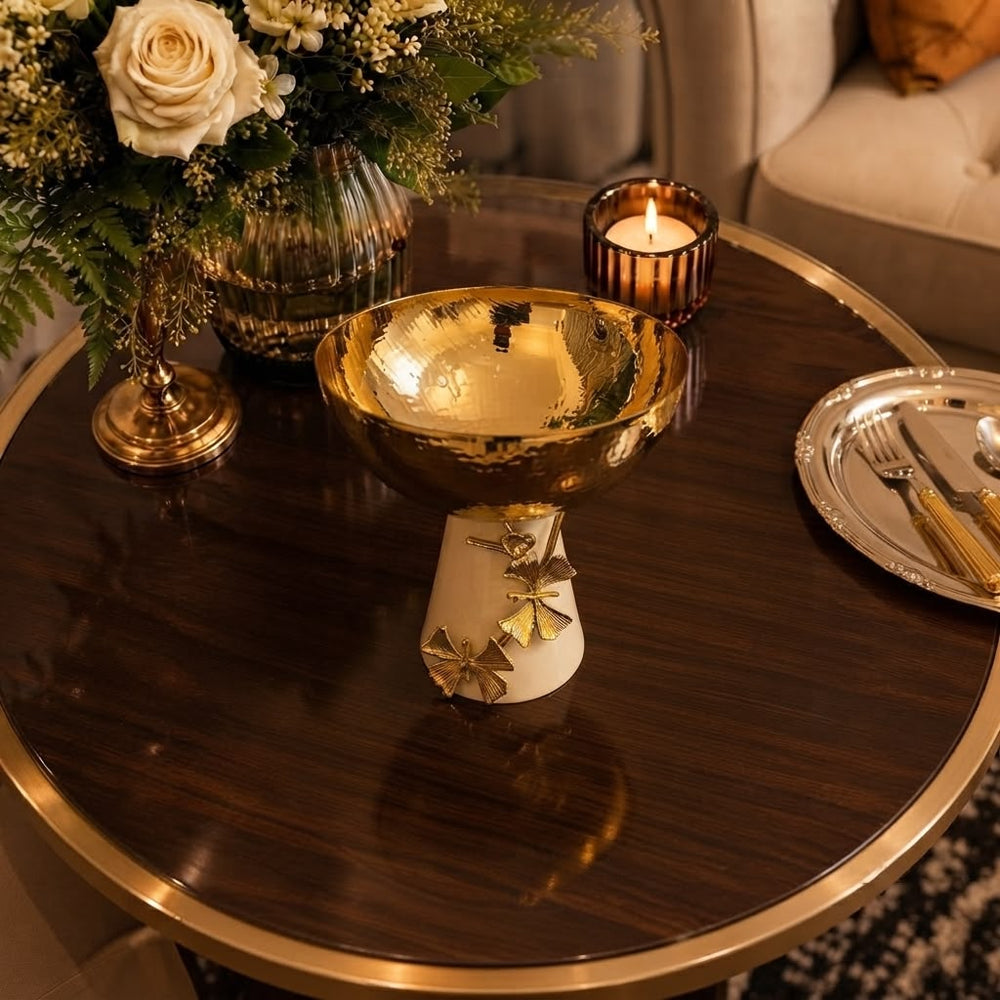 Home Sajawat decorative pedestal bowl with a hammered gold-tone finish and cream ceramic base with ginkgo leaf detail.