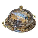 Home Sajawat hammered stainless steel serving dome with ornate gold handles and matching tray. Elegant hammered finish.