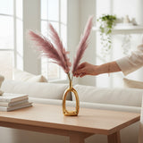 Home Sajawat artificial lavender pampas grass in a modern gold open-center ceramic vase on a wooden table.