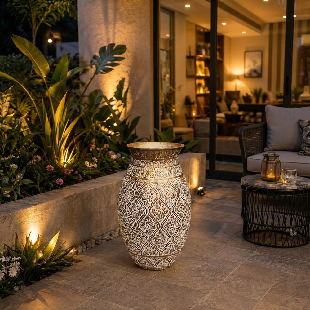 Home Sajawat ornate metallic floor vase with intricate embossed patterns on a patio at night