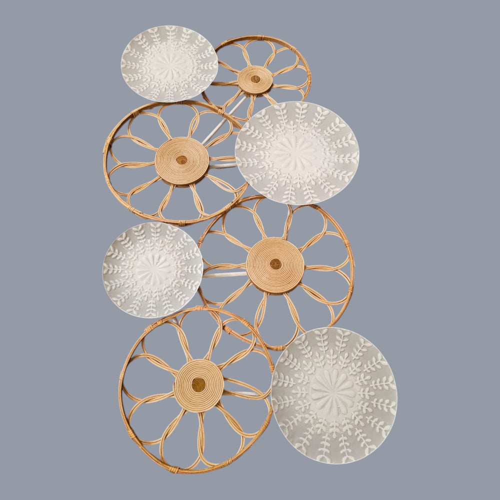 Home Sajawat set of four decorative wall plates with woven rattan frames and embossed botanical motifs in neutral tones.