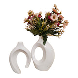 Home Sajawat set of two white ceramic vases with abstract hollow-center designs and a bouquet of faux flowers