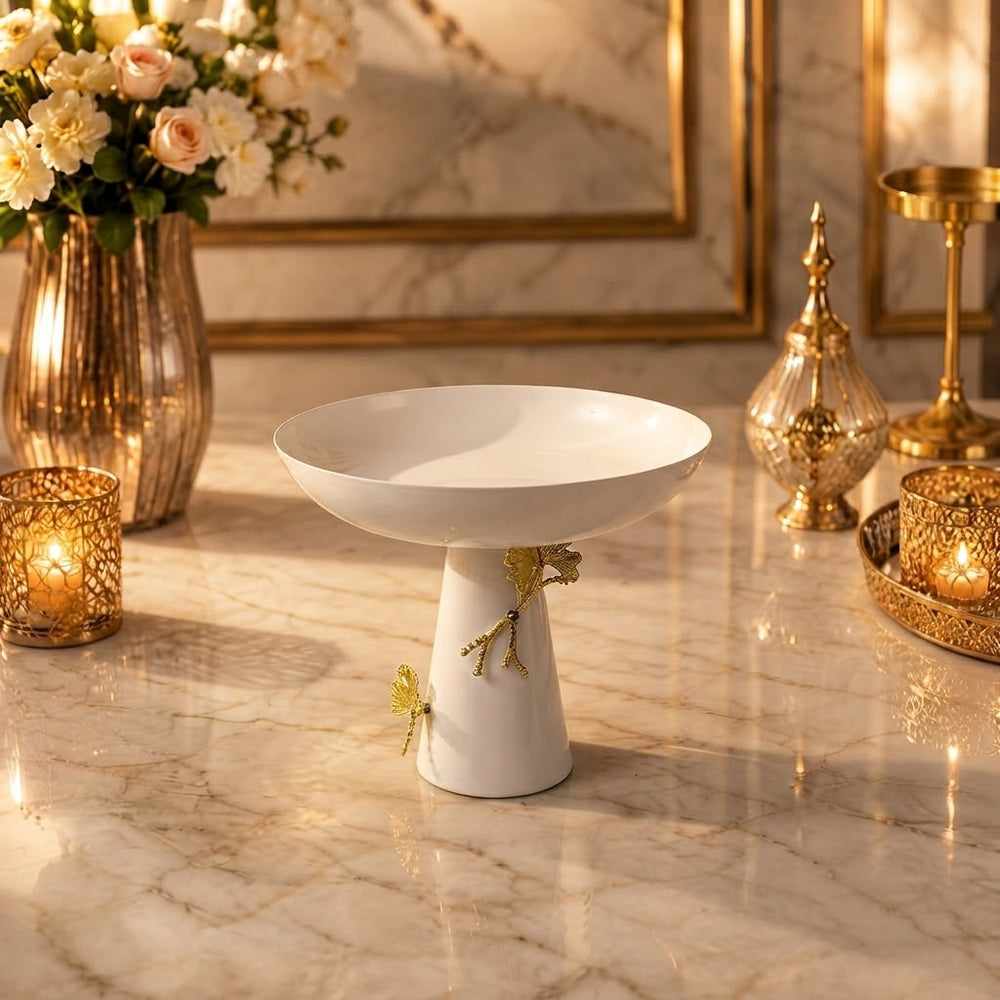 Home Sajawat white ceramic pedestal bowl with gold floral accents on a marble table centerpiece