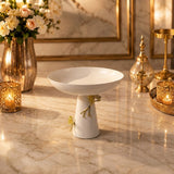 Home Sajawat white ceramic pedestal bowl with gold floral accents on a marble table centerpiece