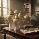 Home Sajawat set of three white ceramic temple jars with gold vertical stripes and finials. Varying sizes.