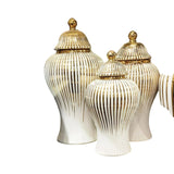 Home Sajawat set of three white ceramic temple jars with gold vertical stripes and finials.