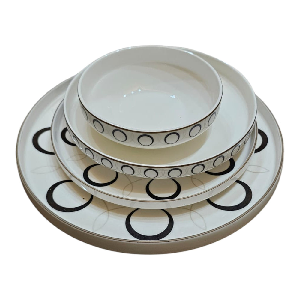 Home Sajawat white ceramic dinnerware set with black geometric circles and gold rim. Includes plates and bowls.